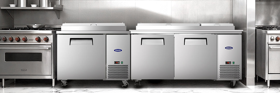 Commercial prep table and worktop refrigerators in a stainless steel kitchen setup.